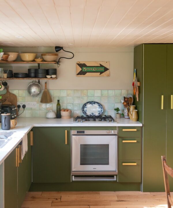 gold tau kitchen handle on olive green kitchen units in a kitchen