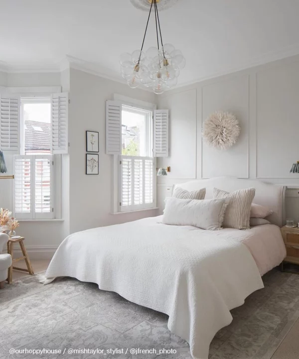A clear bubble chandelier in a neutral bedroom.