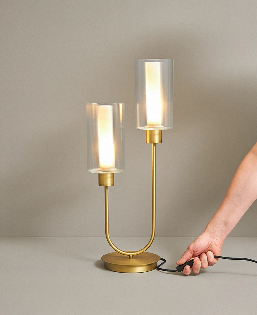 gold table lamp with two bulbs in ribbed glass shades