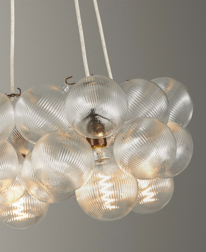close up shot of a Dowsing & Reynolds fluted bubble chandelier with linen fabric cable and antique brass hardware